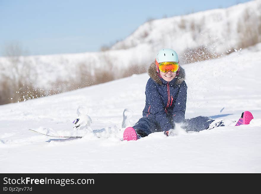 Picture of athlete woman in helmet sitting at snowdrift