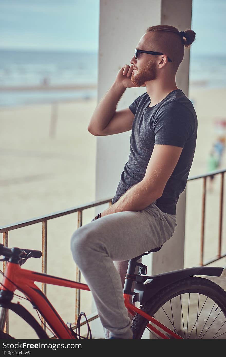 A handsome redhead male with a stylish haircut and beard dressed