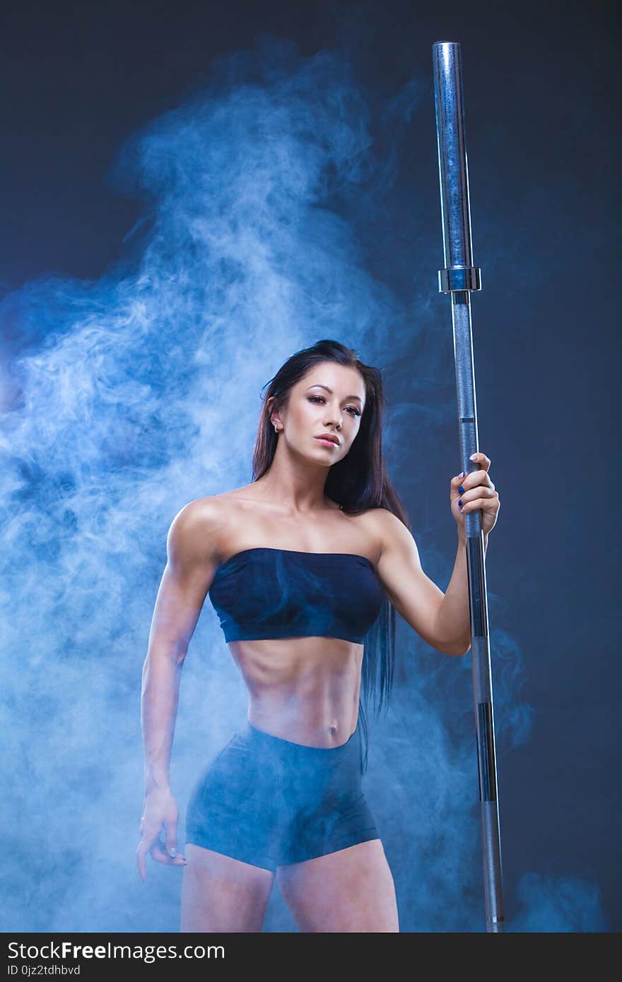 Brutal athletic woman holds a barbell. The concept of exercise sports, advertising a gym.Isolated on a black background