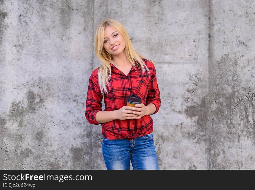 It`s coffee time! Coffee time concept. Woman with beaming smile drinking coffee. Close up portrait, grey background