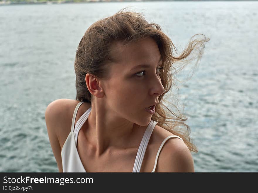 Beautiful young girl with brown hair and awesome eyes on the ocean beach in the metropolis Hong Kong