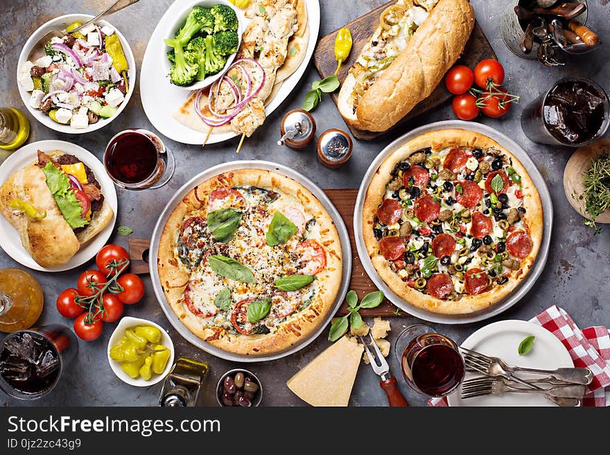 Big dinner with pizza, salad and sandwiches overhead view. Big dinner with pizza, salad and sandwiches overhead view