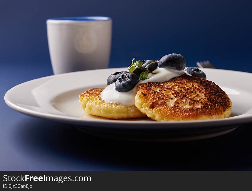 Cottage cheese pancakes with blueberries and cup of black coffee.