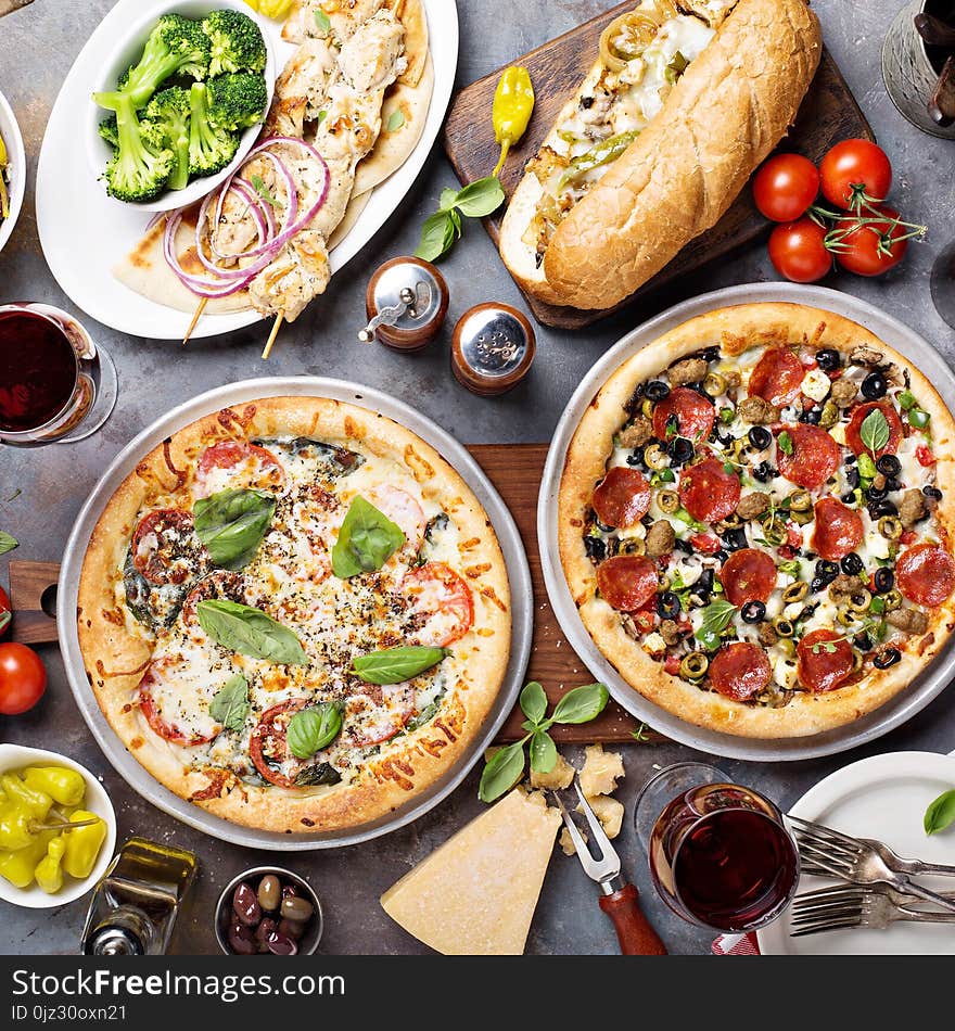 Big dinner with pizza, salad and sandwiches overhead view. Big dinner with pizza, salad and sandwiches overhead view