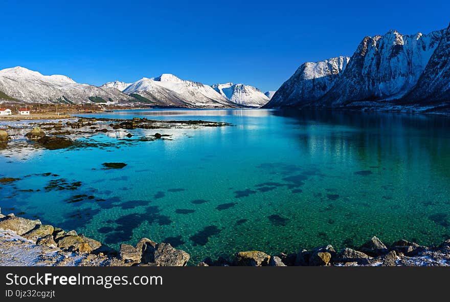 Panoramic view of beautiful winter lake with snowy mountains at Lofoten Islands in Northern Norway. Panoramic view of beautiful winter lake with snowy mountains at Lofoten Islands in Northern Norway