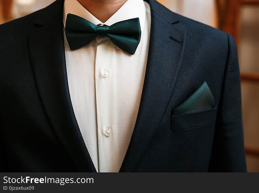 Groom black suit with a green bow tie. Groom black suit with a green bow tie