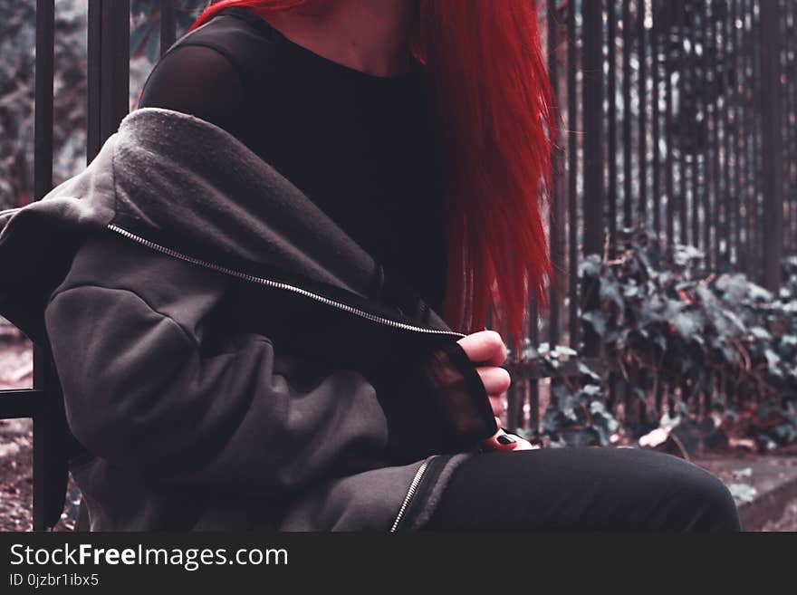 Woman in Black Zip-up Jacket Near Green Leaf Plant