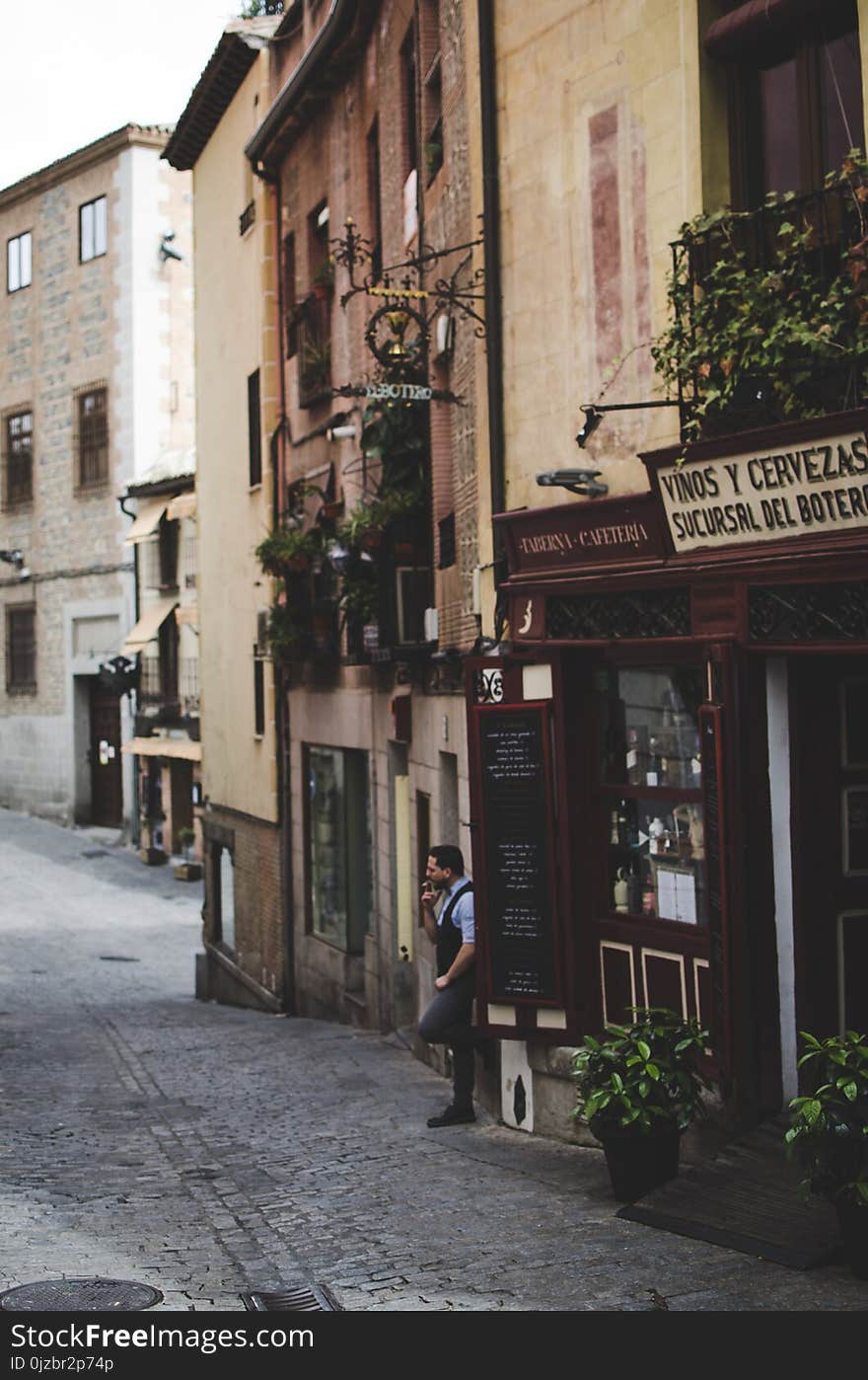 Man Standing on Gray Alley While Smoking