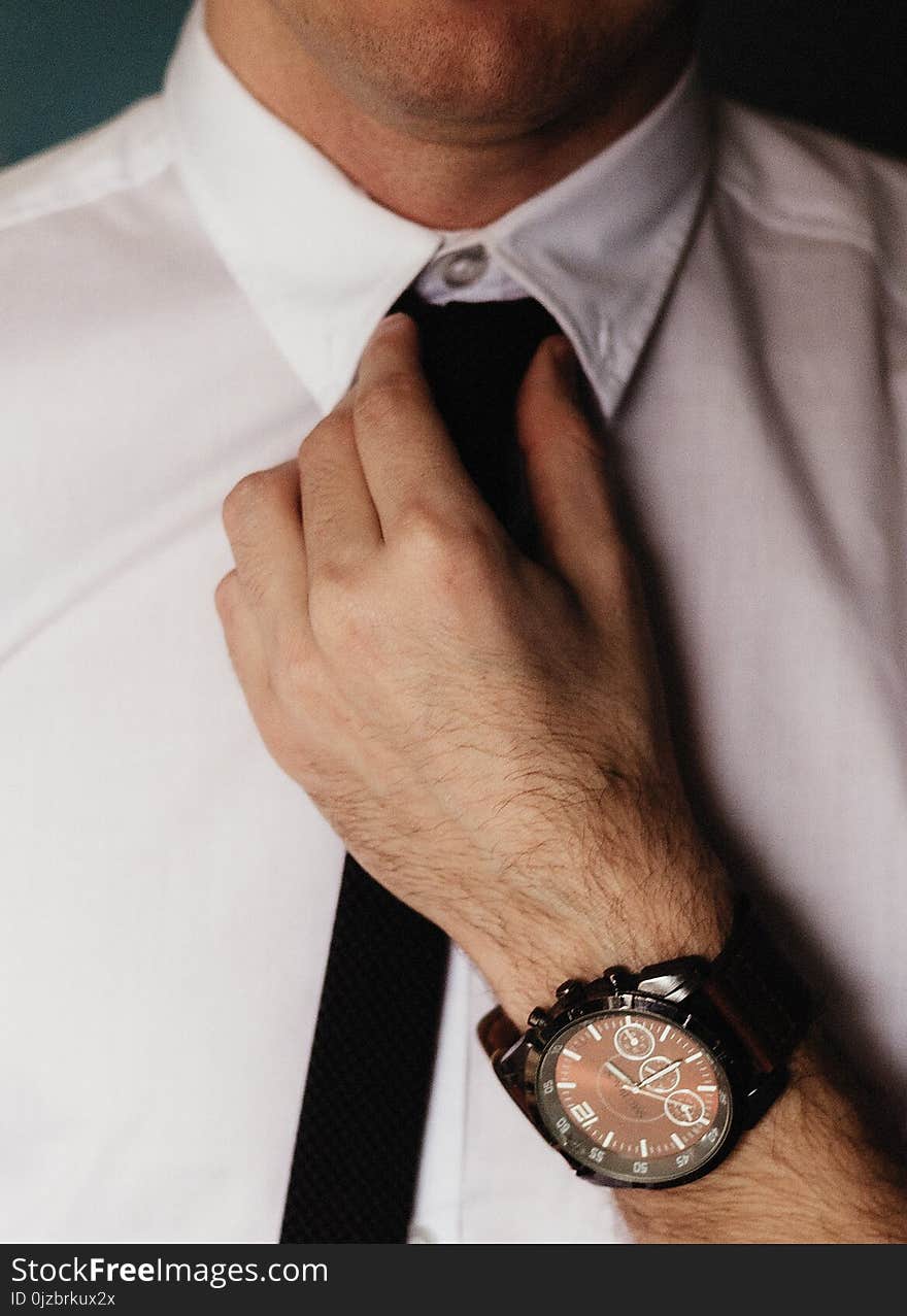 Person Wearing White Dress Shirt Holding Black Necktie