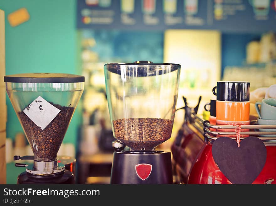 Two Clear Glass Coffee Makers Beside Black and Beige Ceramic Mug