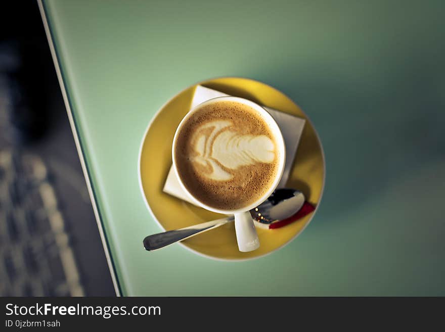 Coffee Latte on Saucer Beside Spoon