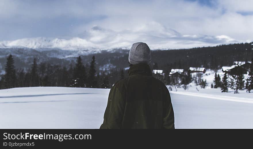 Man With Black Jacket and Grey Knit Cap Standing on White Snow Field