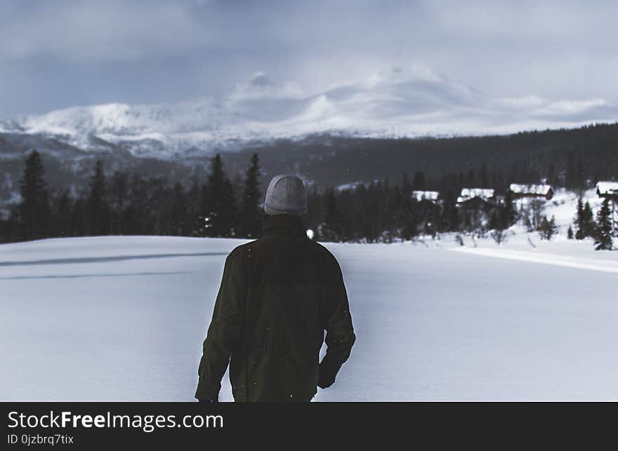 Man Wearing Black Jacket Walking in the Snow