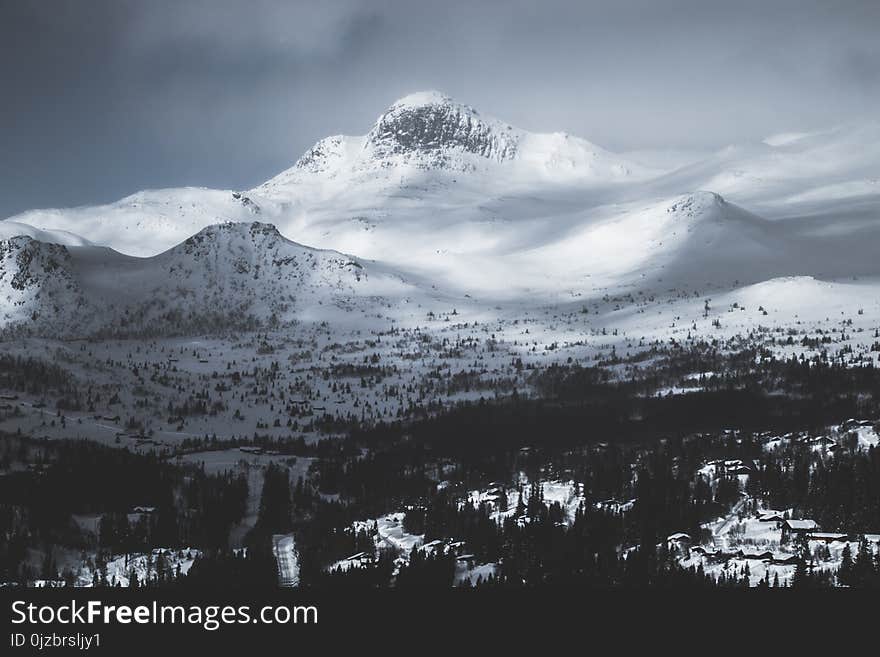 Mountain Coated With Snow Under Gray Sky