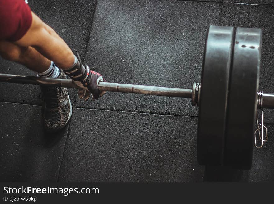 Person in Red Shirt Lifting a Barbell