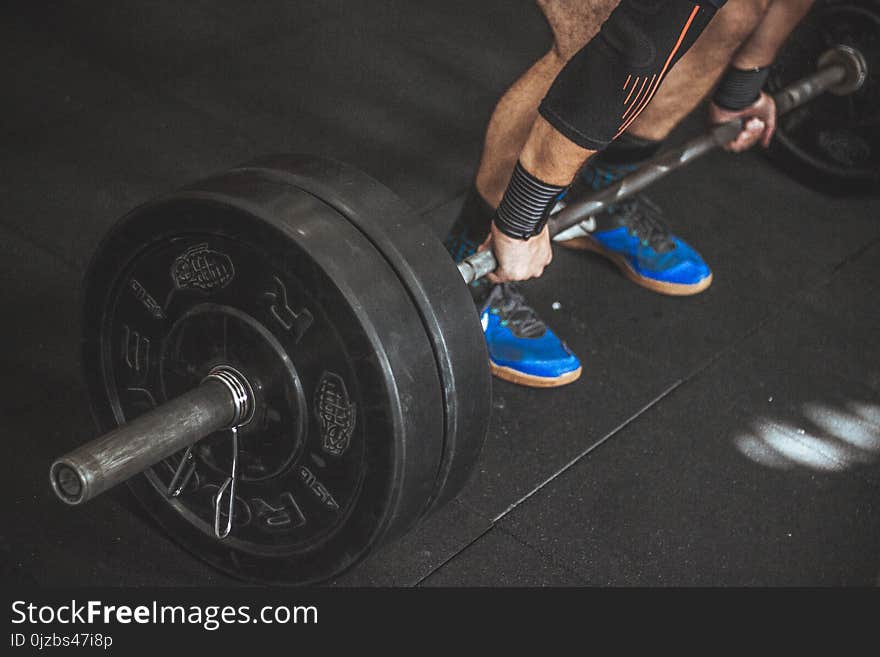 Close-up of a Person&#x27;s Lower Body Holding Barbell