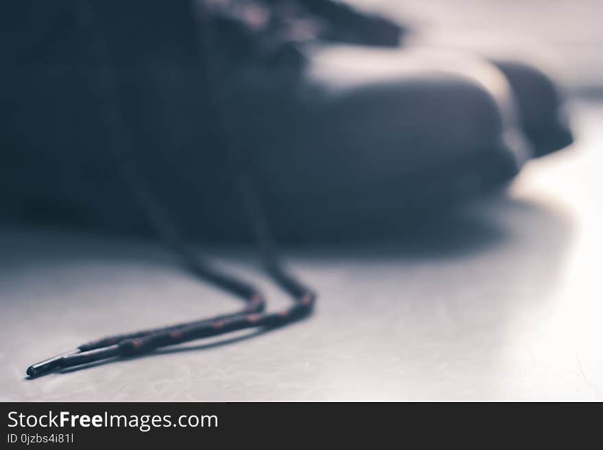 Black Shoelace Placed on Gray Floor