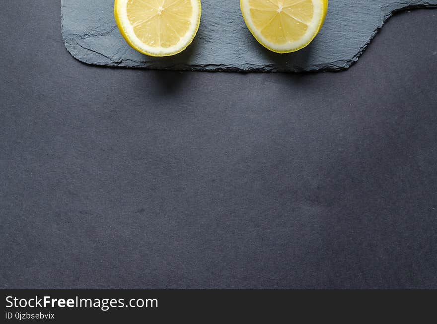 Two Sliced Lemons on Black Surface