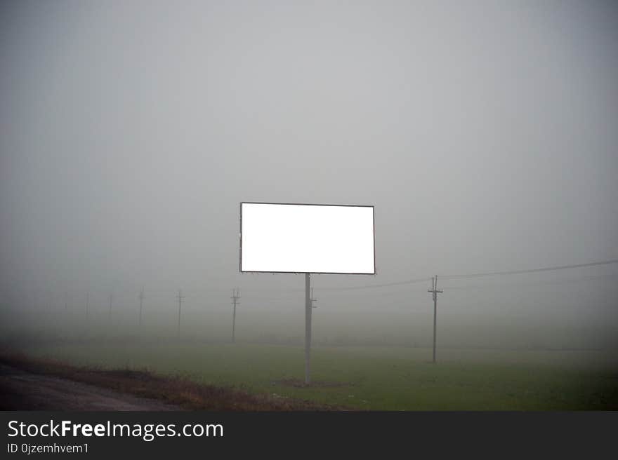 Isolated billboard template on a foggy road