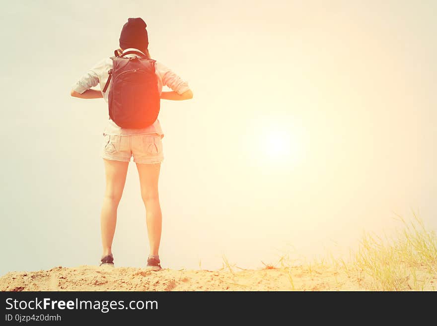 Woman with backpack standing on the beach, travel concetp background