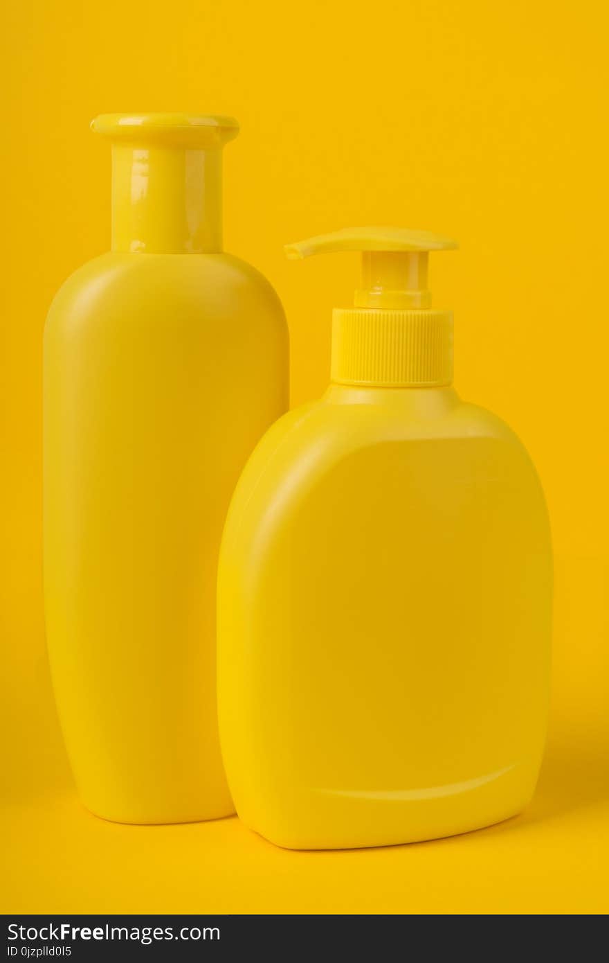 Group Cosmetic Bottles Isolated on Yellow Background.