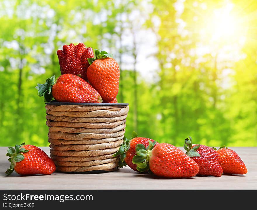 Ripe sweet strawberries in wooden basket.