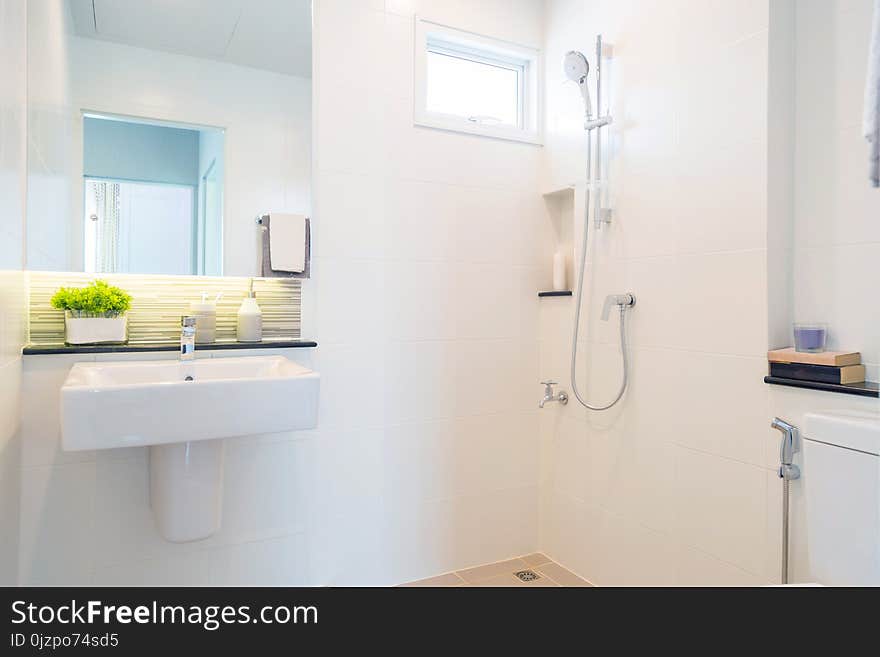 Bathroom picture with a basin with mirror and a shower.