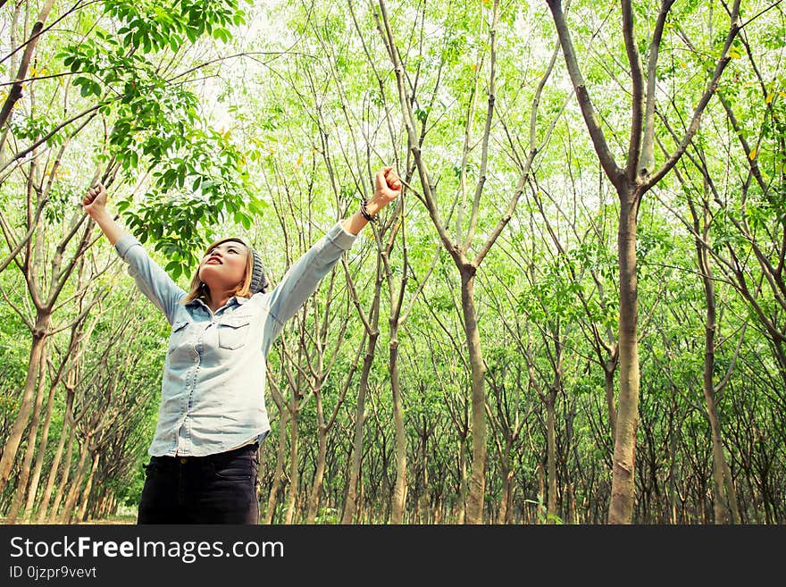 Beautiful young woman enjoying with nature in the forest background