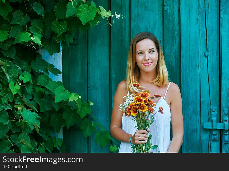 Beautiful young woman holding a bouquet of wild flowers . Portrait of a healthy smiling girl. Beautiful young woman holding a bouquet of wild flowers . Portrait of a healthy smiling girl