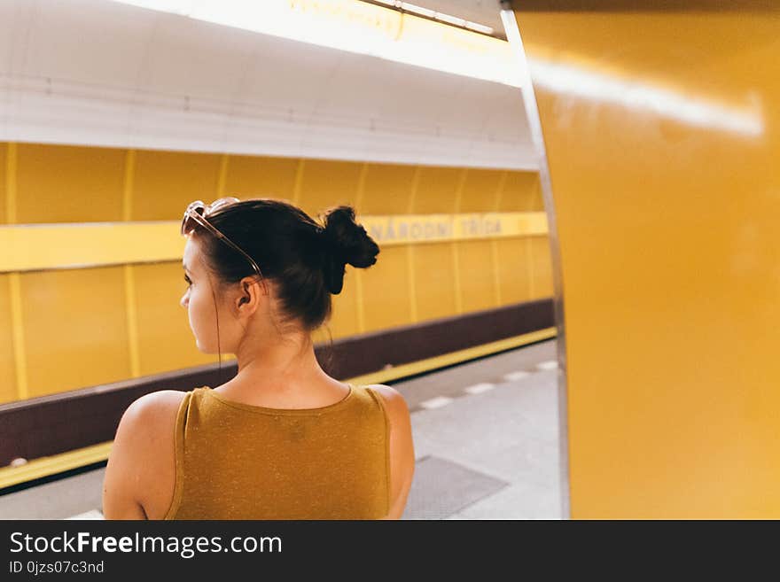 Woman Wearing Gold Sleeveless Top Inside the Building