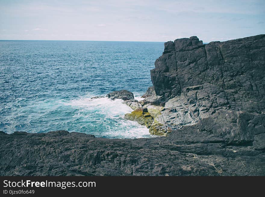 Landscape Photography of Boulder Near Body of Water