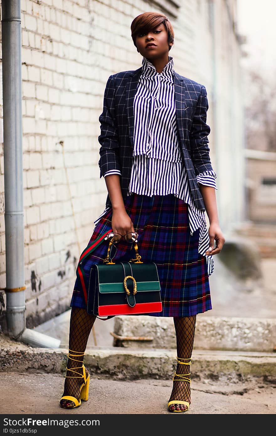 Woman in Blue and White Plaid Cardigan Holding Green and Red Handbag