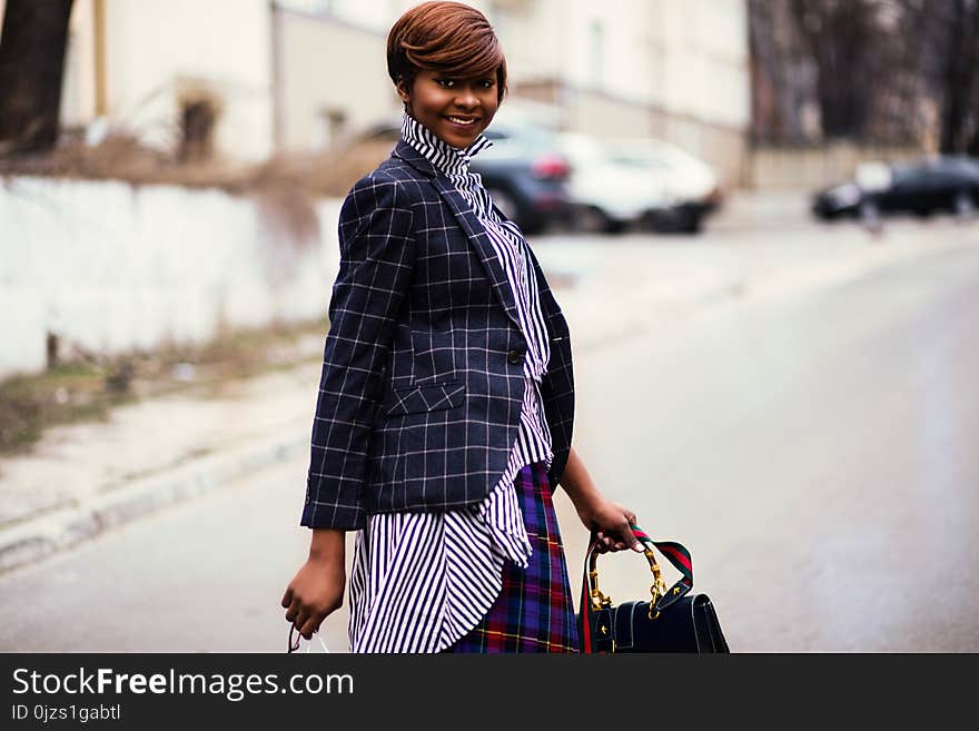 Photo of Woman in Black and Gray Blazer Holding Bag