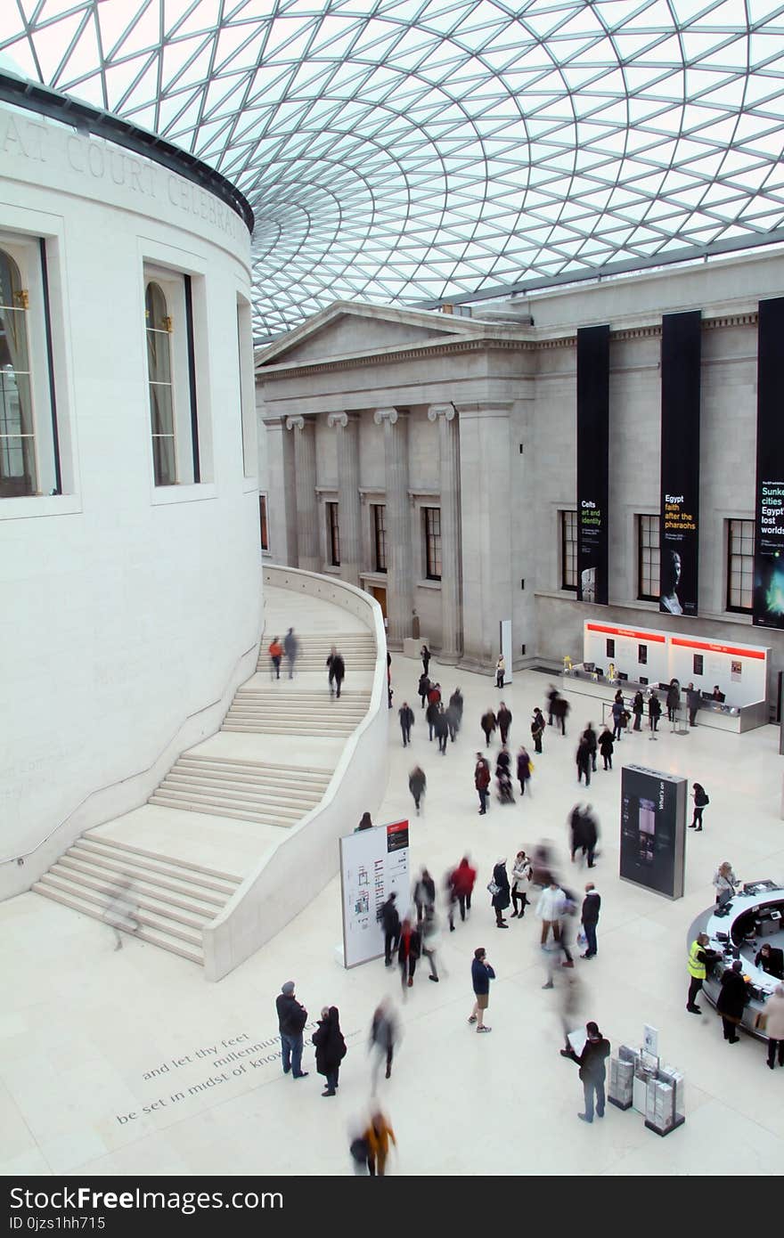 People Waling Inside White Concrete Building