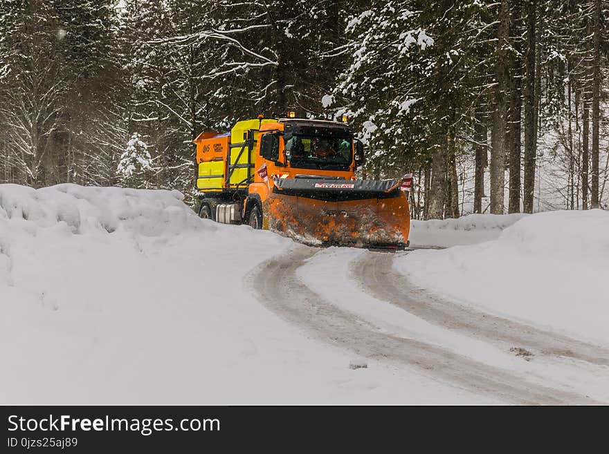 Yellow, Orange, and Black Truck Plowing Snow