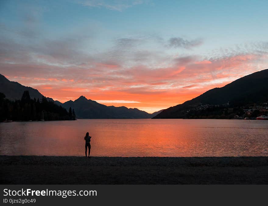 Silhouette Photo of Person Standing Near Body of Water