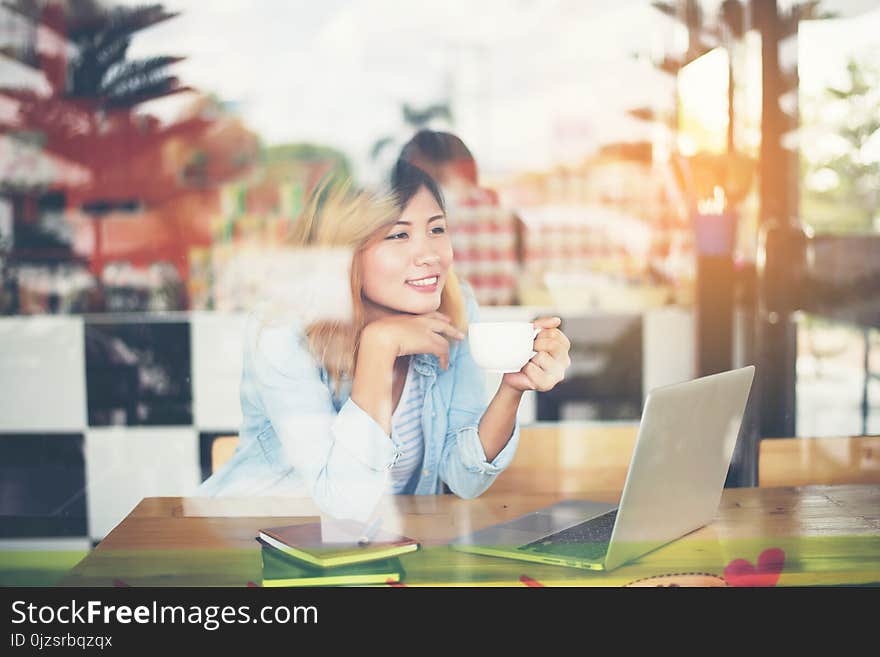 Young beautiful hipster woman work at cafe with window reflection background. Young beautiful hipster woman work at cafe with window reflection background