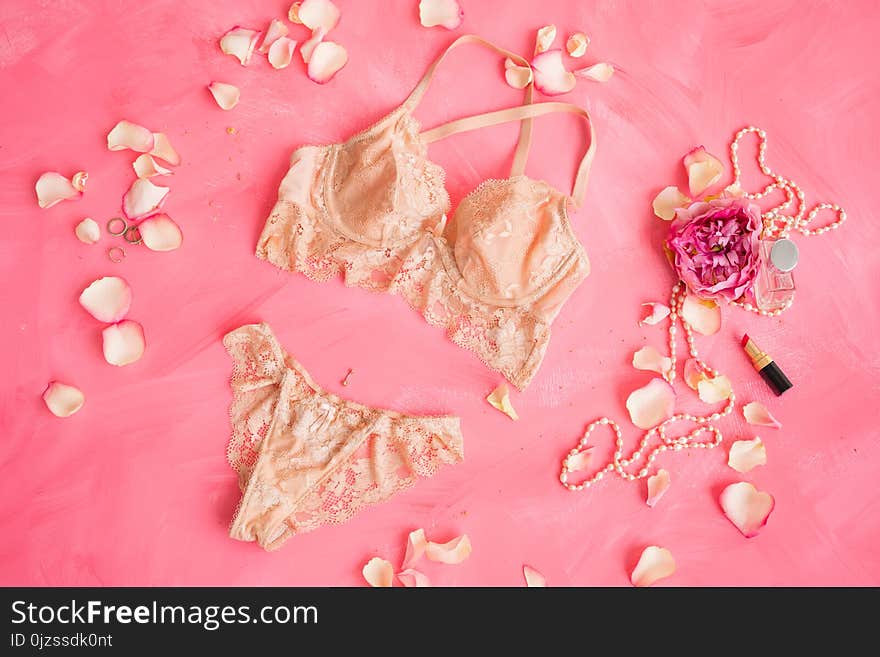 Beige women`s lingerie on pink background, underwear concept