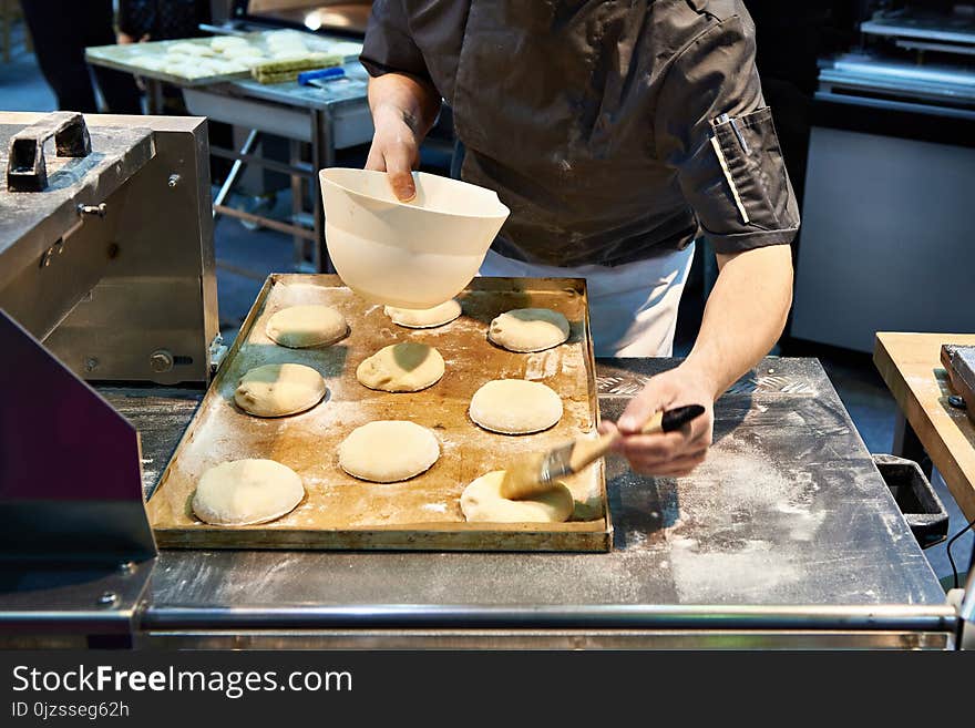 Baker prepares buns for baking