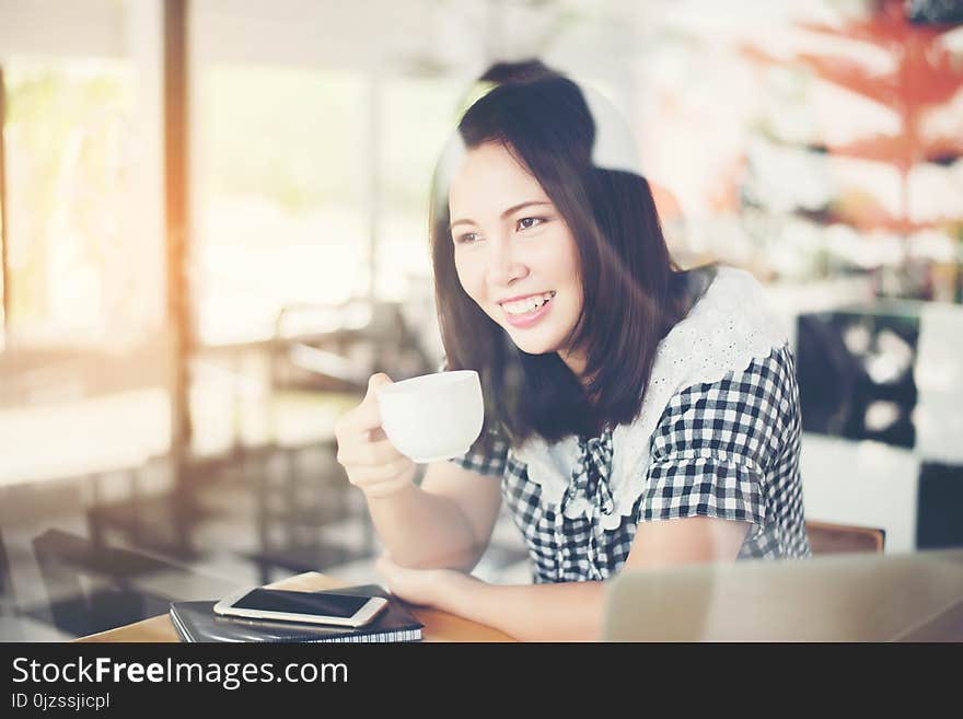 Beautiful Woman Sitting And Drinking Coffee At Cafe.