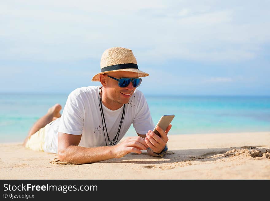 Man with mobile phone on the beach