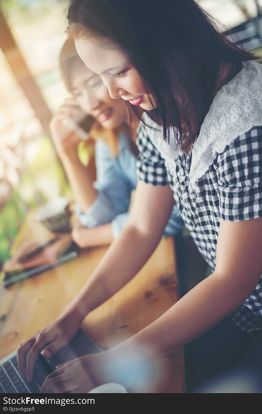 Two friends enjoying working together with window reflection in