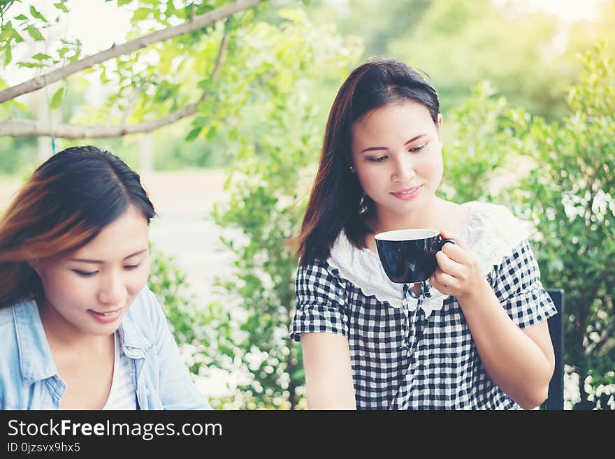 Two friends smiley enjoying working together in a coffee shop background. Two friends smiley enjoying working together in a coffee shop background