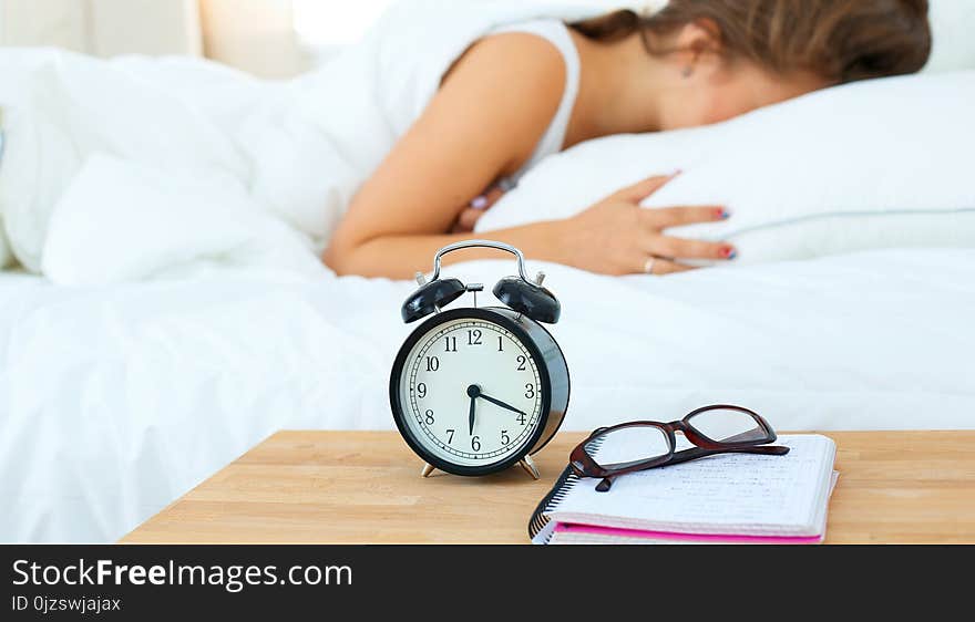 A Young Woman Putting Her Alarm Clock Off In The Morning