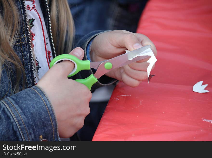 Hands of a girl carving out paper for crafts