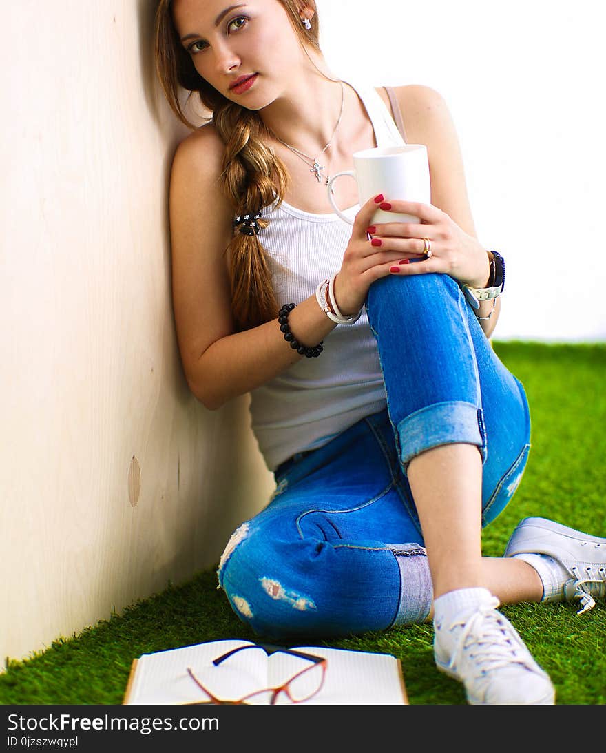 Young woman sitting with book on grass