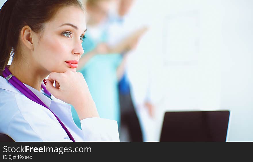 Beautiful Young Smiling Female Doctor Sitting At The Desk