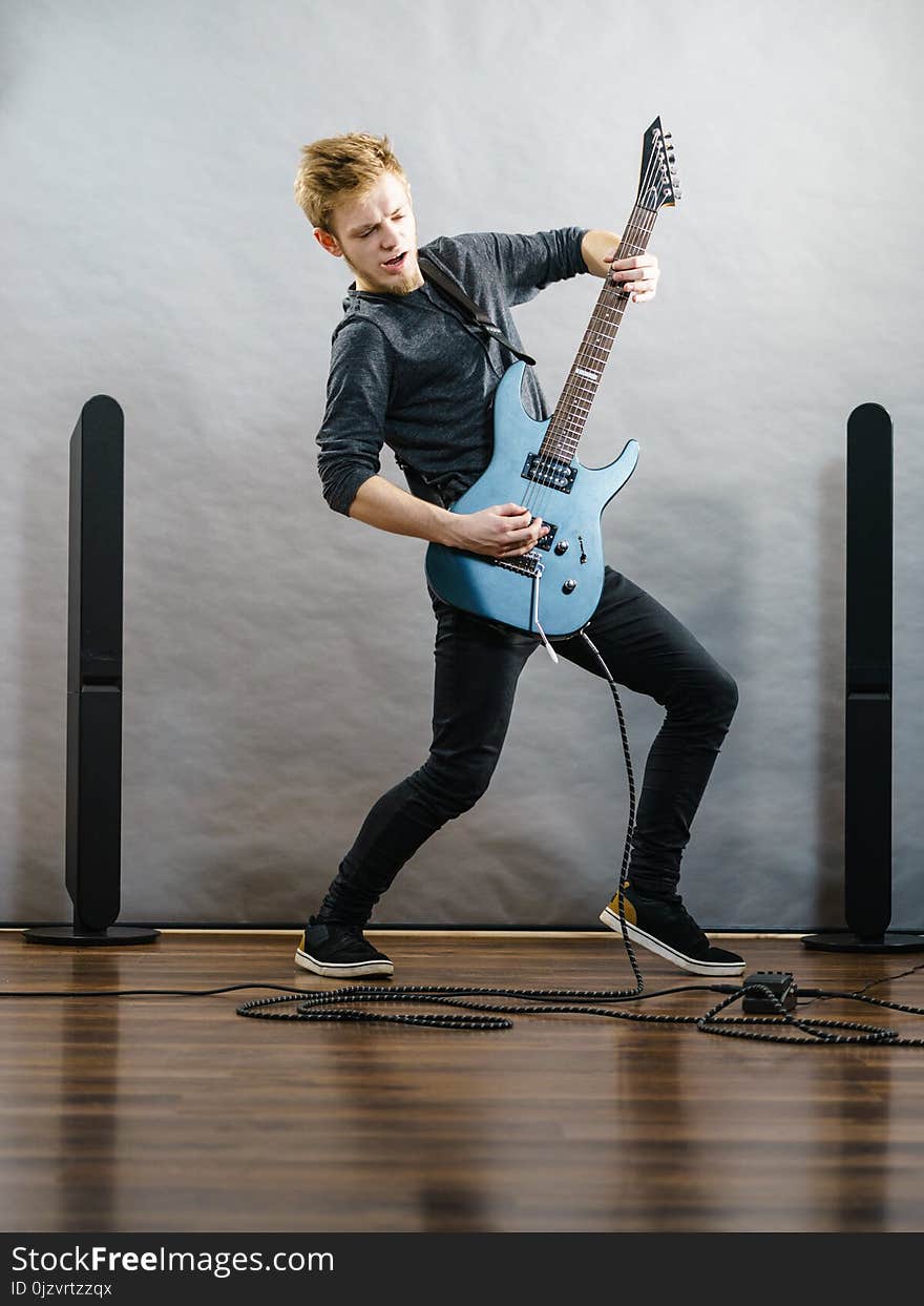 Young man playing electric guitar