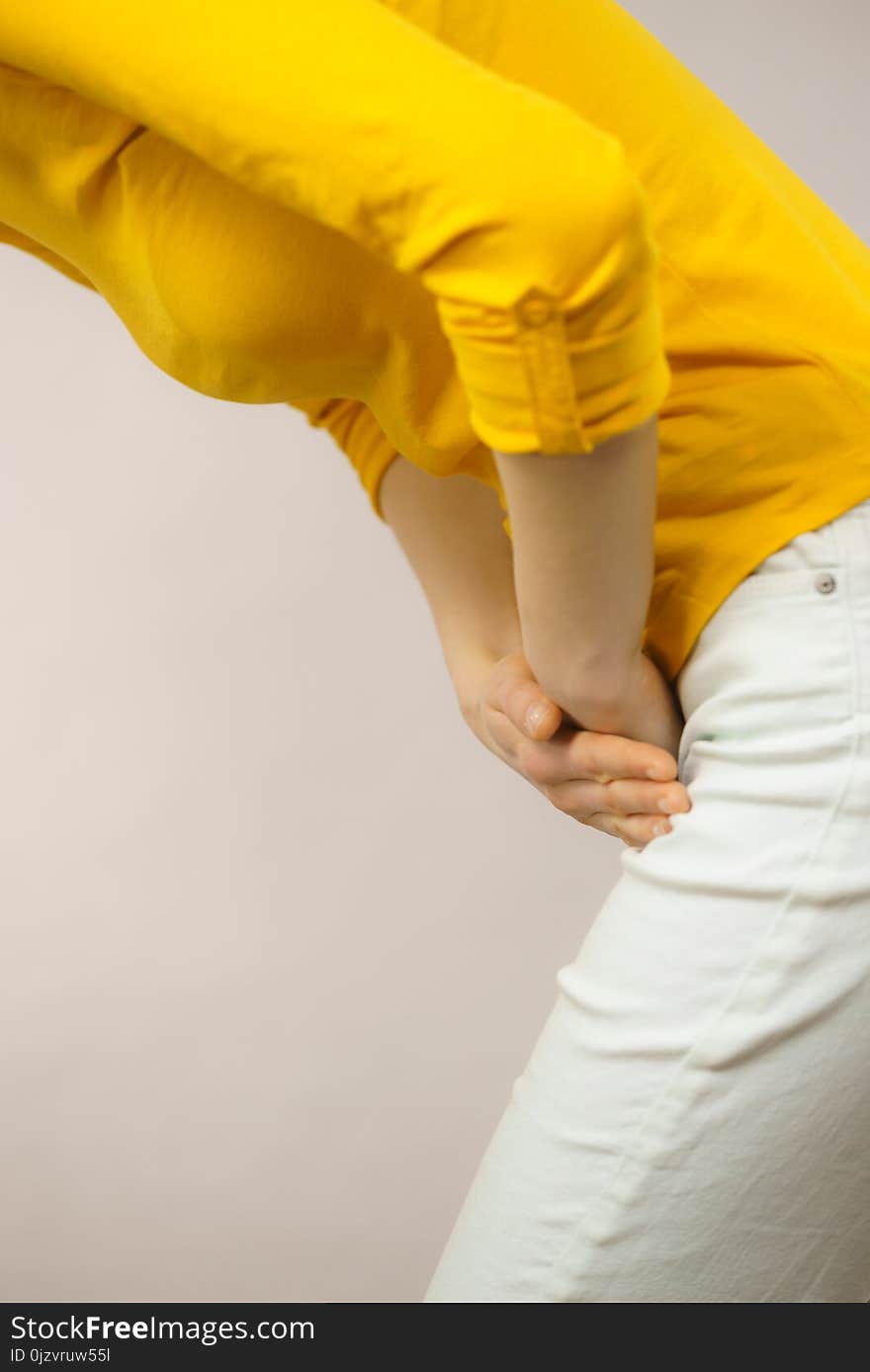 Closeup young sick woman with hands holding pressing her crotch lower abdomen. Medical or gynecological problems, healthcare concept. Closeup young sick woman with hands holding pressing her crotch lower abdomen. Medical or gynecological problems, healthcare concept