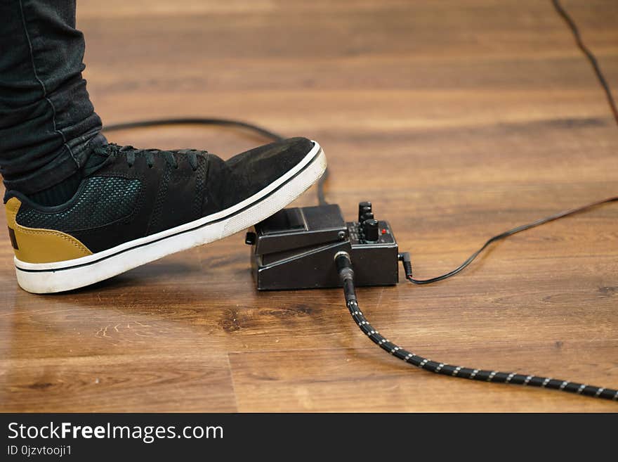 Man with musical instrument setting up guitar audio stomp box effects and cables in music studio. Man with musical instrument setting up guitar audio stomp box effects and cables in music studio